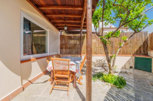 a patio with two chairs and a table and a tree at Azzurro Mare a Seccheto - Goelba in Seccheto