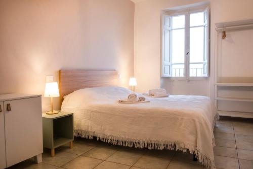 ein Schlafzimmer mit einem großen weißen Bett mit zwei Lampen in der Unterkunft Fontebella 46 in Assisi
