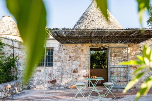 a stone building with a table and two chairs at Sopra i Sassi - Villa & Trulli in Ostuni