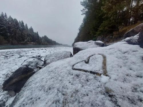 a heart carved in the snow on rocks next to a river at Apart Lechtraum in Stanzach