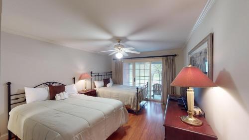 een slaapkamer met 2 bedden en een plafondventilator bij Golfers Paradise 3 BR Villa on the 9th Fairway in Pawleys Island