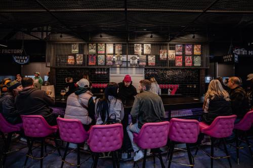 a group of people sitting in chairs at a bar at Brewhalla Hotel in Fargo