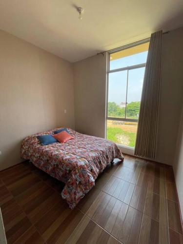 - une chambre avec un lit et une grande fenêtre dans l'établissement Departamento bonito en Tarapoto, à Tarapoto