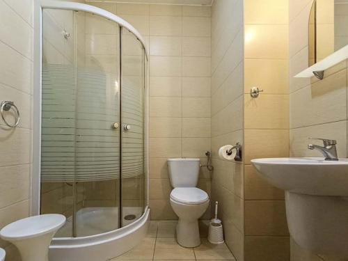 een badkamer met een douche, een toilet en een wastafel bij Sami Swoi Kutno in Kutno