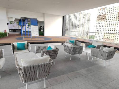 a room with chairs and tables in a building at Seaview Infinity Pool #6pax #2bedroom #2bathroom in Jelutong