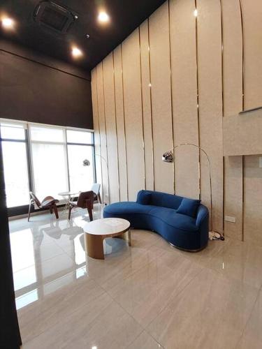 a living room with a blue couch and a table at Seaview Infinity Pool #6pax #2bedroom #2bathroom in Jelutong