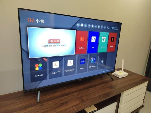 a flat screen tv sitting on top of a wooden table at Seaview Infinity Pool #6pax #2bedroom #2bathroom in Jelutong