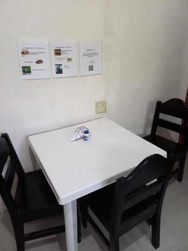 einen weißen Tisch und zwei Stühle in einem Zimmer in der Unterkunft Nick's Place Room #1 in Pavones