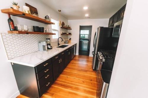 kuchnia z czarną lodówką i drewnianą podłogą w obiekcie Mid Century Modern 2 Bedroom, Walk to Downtown w mieście Grants Pass