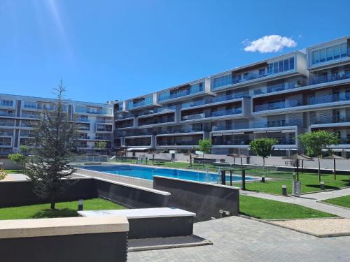 un edificio de apartamentos con piscina frente a él en El Jardín de Galatea, en Alcalá de Henares