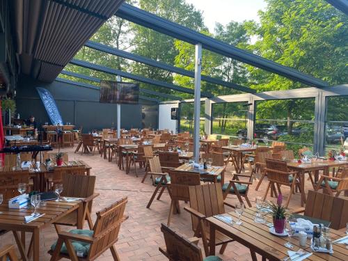 an empty restaurant with wooden tables and chairs at Pastravaria Zavoi in Valea Danului