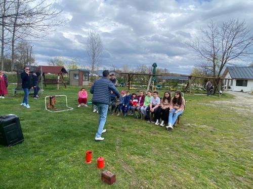 a man playing with a group of children in a park at Pastravaria Zavoi in Valea Danului