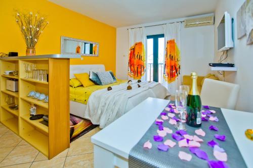sypialnia z łóżkiem i stołem z fioletowymi kwiatami w obiekcie Villa Softic w Hvarze