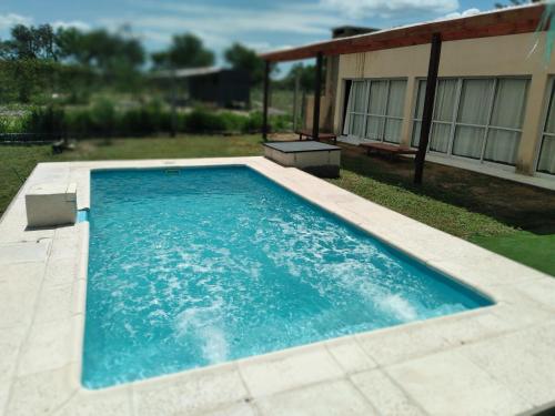 a swimming pool in the yard of a house at Finca Los Chichelos in Santiago del Estero