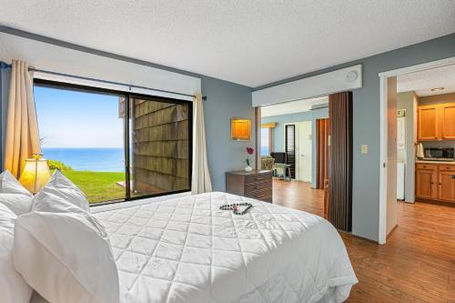 a bedroom with a large white bed with a large window at Sealodge E4 in Princeville