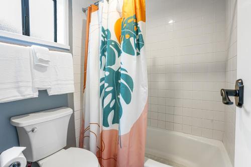 a bathroom with a toilet and a shower curtain at Sealodge E4 in Princeville