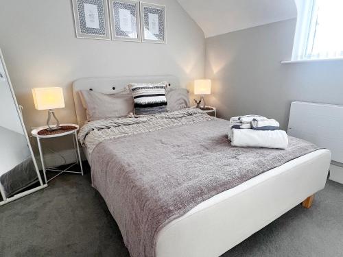 een slaapkamer met een groot wit bed met 2 lampen bij Lakeside LUX bedroom with parking, M4 Jct 11, next to train station in Reading