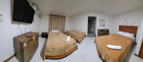 Habitación con 3 camas y TV de pantalla plana. en Andy's House en San Andrés