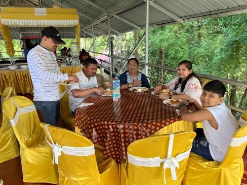 a group of people sitting around a table eating at Marari Beach Villas in Mararikulam