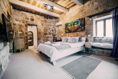 a bedroom with a large bed in a stone wall at Private Villa in Naxxar