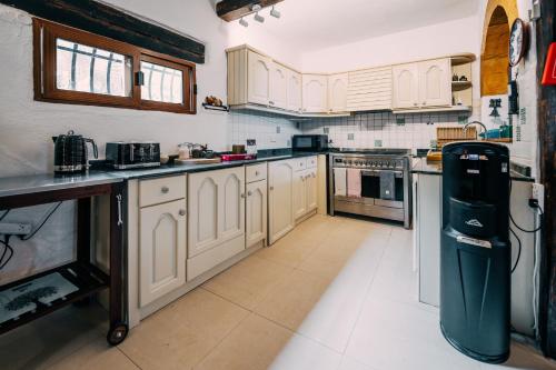 a kitchen with white cabinets and a refrigerator at Private Villa in Naxxar
