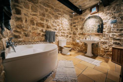 a stone bathroom with a tub and a sink at Private Villa in Naxxar