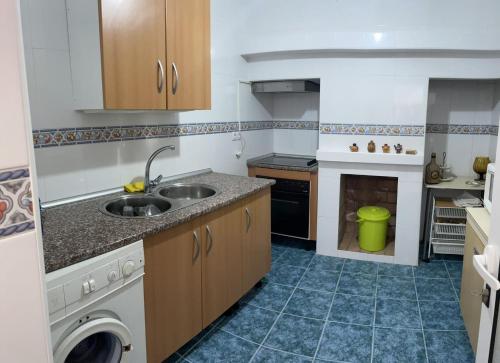 una pequeña cocina con fregadero y lavavajillas en Alojamiento Orellana, en Orellana la Vieja