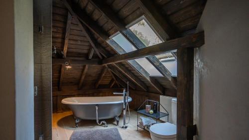 an attic bathroom with a tub and a toilet at Joy Village in Warsaw