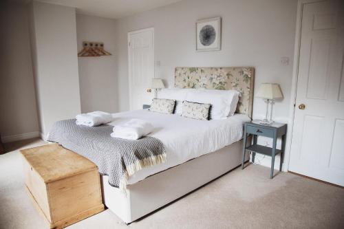 sypialnia z łóżkiem z białą pościelą i poduszkami w obiekcie Glebe House w mieście Barford Saint Martin