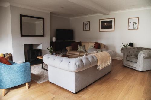 a living room with a couch and two chairs at Glebe House in Barford Saint Martin