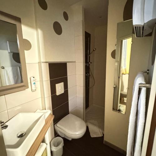 a small bathroom with a toilet and a sink at Cit'Hotel Les Alizes in Dinard