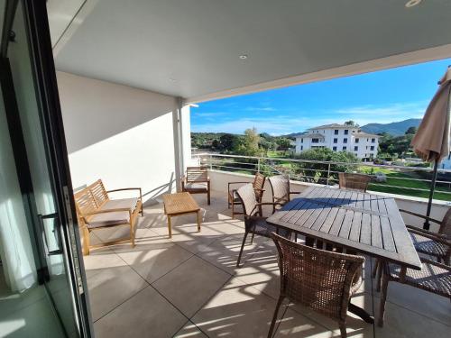 un balcon avec une table et des chaises et une vue dans l'établissement Domaine d'Arca - Flaubert 22 - 3 pièces - étage 2 - Porto-Vecchio, à Porto-Vecchio