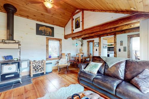 uma sala de estar com um sofá de couro e uma lareira em Grizzly Pines em Jay