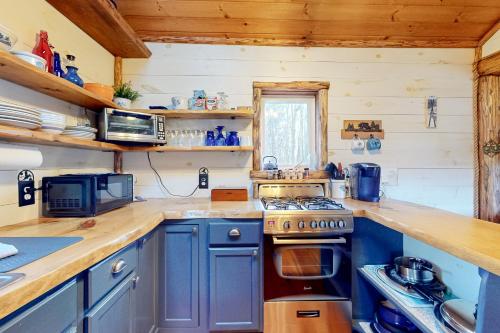 a kitchen with blue cabinets and a stove at Grizzly Pines in Jay