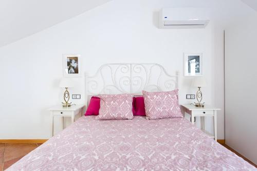een slaapkamer met een groot bed met roze kussens bij EDEN RENTALS Elite Palace Suites in Adeje