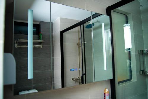 a bathroom with a mirror and a glass shower at Laurel Living 2-Bedroom apartment in Nairobi