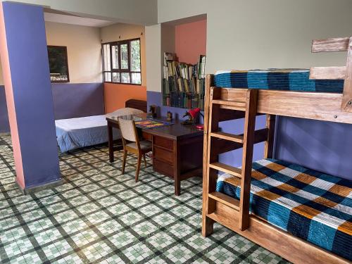 a dorm room with a bunk bed and a desk at El Pueblito in Cochabamba
