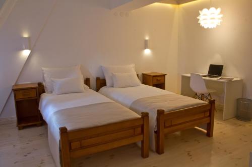 a bedroom with two beds and a desk with a laptop at Hotel Polar Star in Žabljak