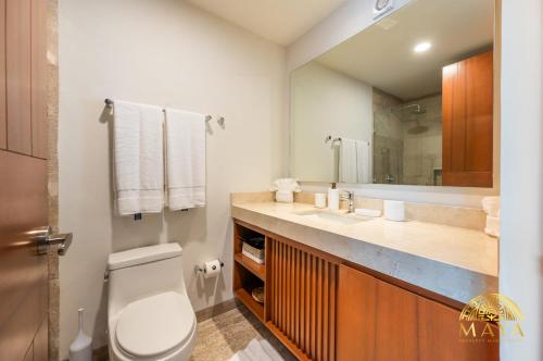 een badkamer met een toilet, een wastafel en een spiegel bij Tulum Village Condominium in Tulum