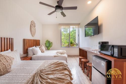 een hotelkamer met 2 bedden en een flatscreen-tv bij Tulum Village Condominium in Tulum