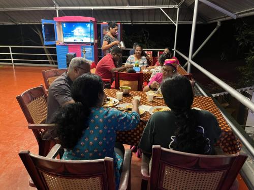 a group of people sitting around a table at Marari Beach Villas in Mararikulam