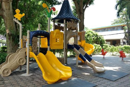 une aire de jeux avec un toboggan jaune et une tour dans l'établissement Malibu Samed Resort, à Ko Samet