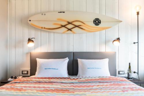 a surfboard hanging on the wall above a bed at Beach Motel St. Peter-Ording in Sankt Peter-Ording
