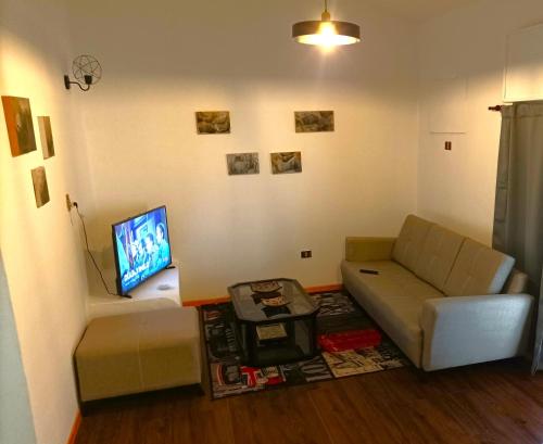 a living room with a couch and a flat screen tv at DEPARTAMENTO RIO TERCERO in Río Tercero