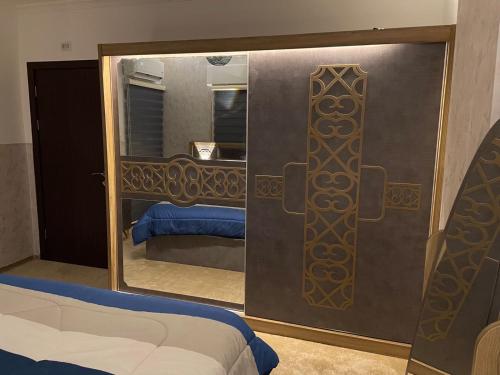 1 dormitorio con espejo y 1 cama en una habitación en شركة مسايا لشقق المفروشة, en Irbid