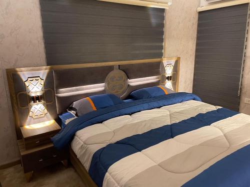 a bedroom with a large bed with blue and white sheets at شركة مسايا لشقق المفروشة in Irbid