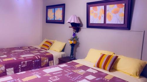 1 Schlafzimmer mit 2 Betten, einer Lampe und 2 Fenstern in der Unterkunft HOTEL VISTA HERMOSA in Trujillo