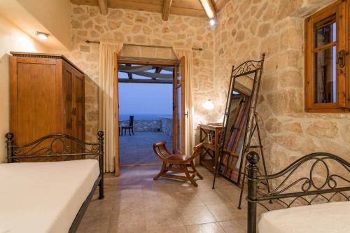 a bedroom with a bed and a table and a chair at Astarte Villas - Diva Affluence with Private Pool in Koríthion