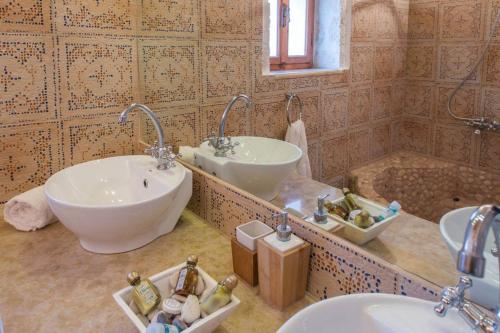 a bathroom with two sinks and a tub at Astarte Villas - Diva Affluence with Private Pool in Koríthion