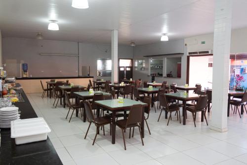 a dining room with tables and chairs in a restaurant at Hotel Grandville III in Palmeira dos Índios